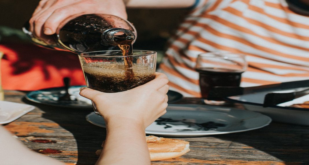 une personne en train de verser de boisson dans un verre